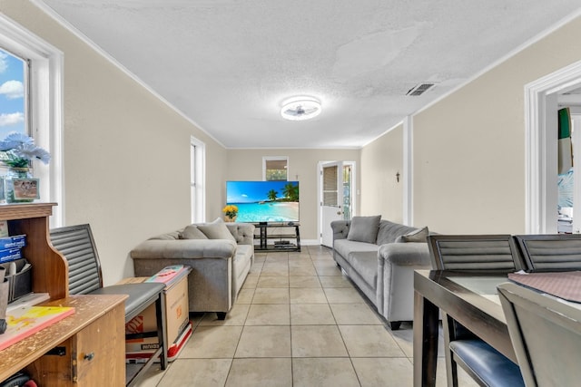 tiled living room with a textured ceiling and ornamental molding