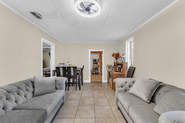 tiled living room featuring ornamental molding and a textured ceiling