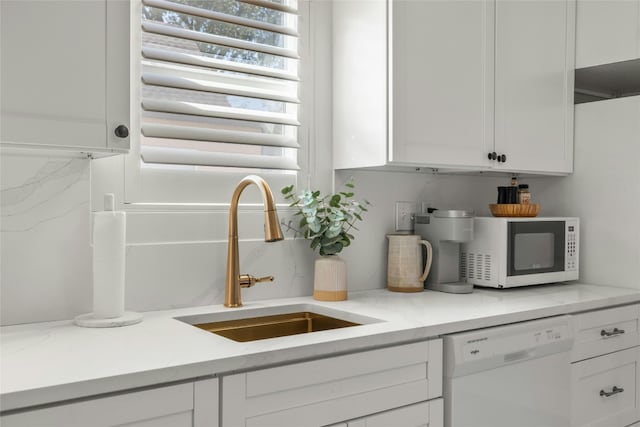 kitchen with radiator, white appliances, sink, light stone countertops, and white cabinetry