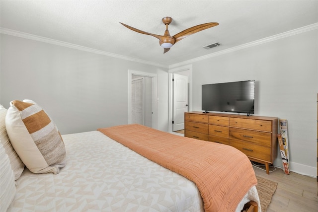 bedroom featuring ceiling fan, a closet, crown molding, and light hardwood / wood-style floors