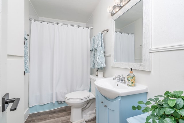 bathroom featuring hardwood / wood-style flooring, toilet, vanity, and curtained shower