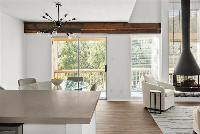 dining area featuring beam ceiling, wood-type flooring, and a chandelier