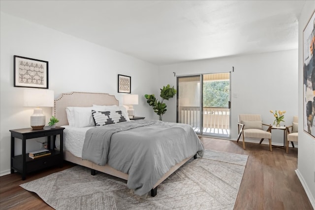 bedroom with dark hardwood / wood-style floors and access to exterior