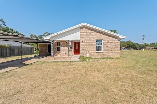 back of house featuring a carport and a lawn