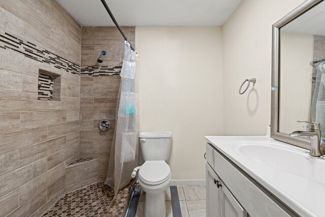 bathroom featuring a shower with curtain, vanity, toilet, and tile patterned floors