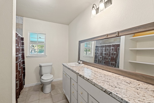 bathroom featuring tile patterned flooring, vanity, toilet, and walk in shower