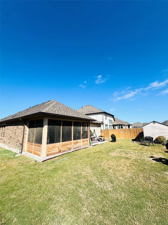 back of property featuring a yard and a sunroom