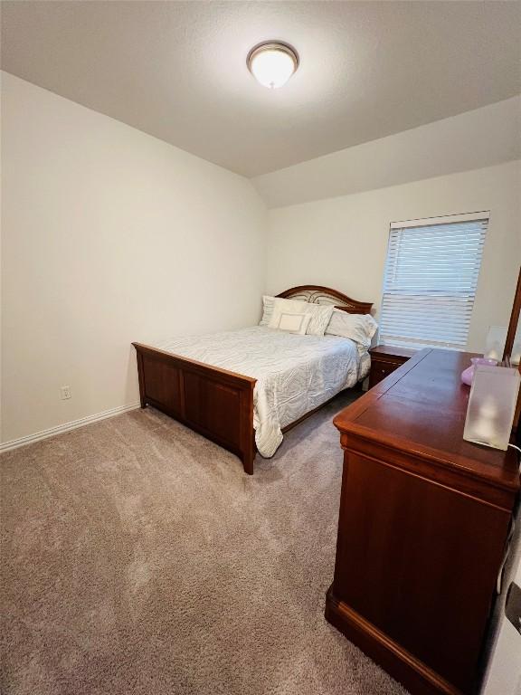 bedroom with carpet flooring and vaulted ceiling