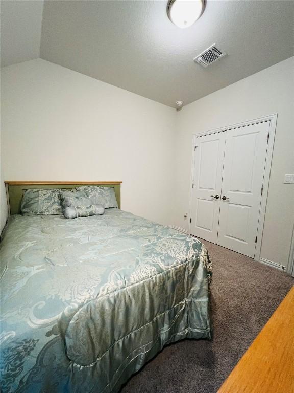 bedroom with vaulted ceiling, a closet, and carpet