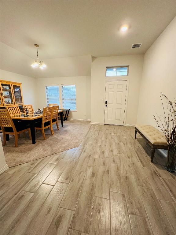 foyer entrance with a notable chandelier and light hardwood / wood-style flooring