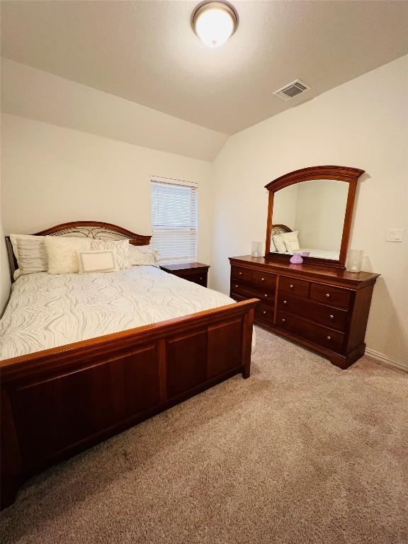 bedroom featuring vaulted ceiling and light colored carpet