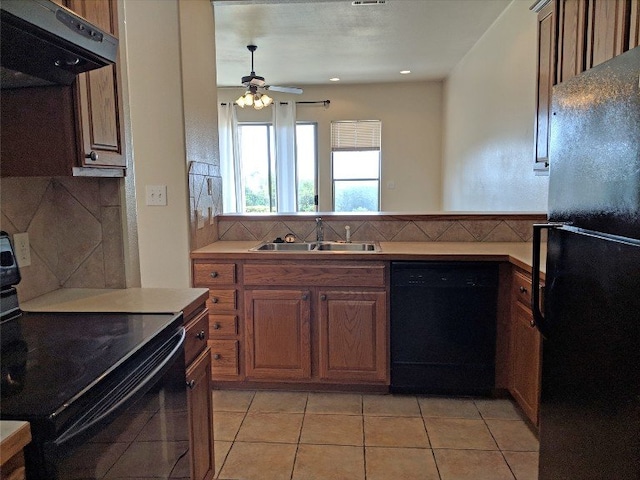 kitchen featuring black appliances, tasteful backsplash, sink, range hood, and light tile patterned floors