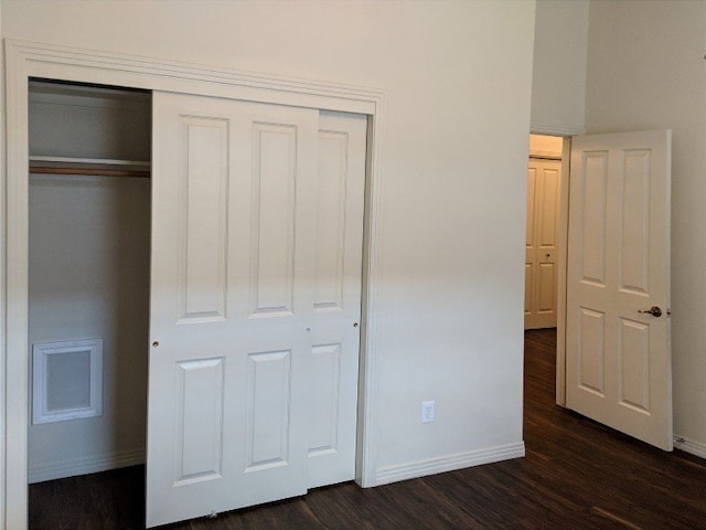 unfurnished bedroom featuring a closet and dark hardwood / wood-style floors