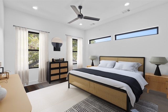 bedroom with ceiling fan, hardwood / wood-style flooring, and multiple windows