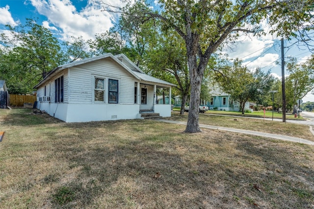 view of front of property with cooling unit and a front yard