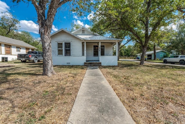 1504 Saint Peter St, Gonzales, TX 78629 - bungalow with a front lawn, a porch, crawl space, and a metal roof