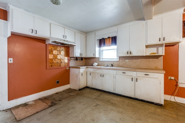 kitchen featuring sink, backsplash, and white cabinets