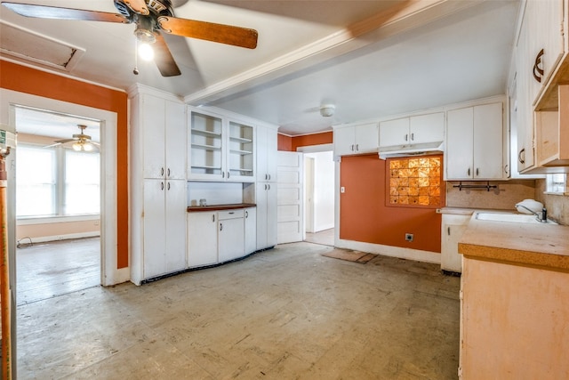 kitchen featuring backsplash, sink, and white cabinetry