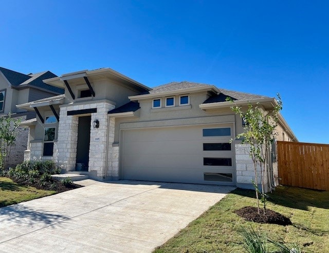 prairie-style home featuring a garage and a front yard