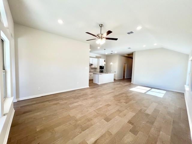 unfurnished living room featuring light hardwood / wood-style floors, ceiling fan, and lofted ceiling