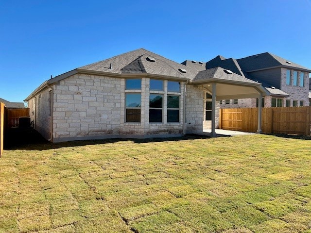 rear view of property featuring a yard