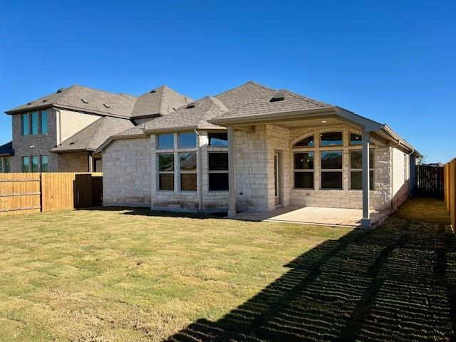 back of house featuring a lawn and a patio area