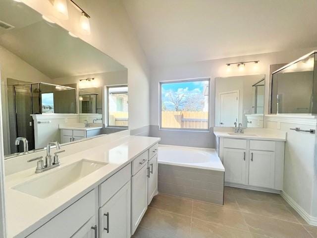 bathroom with tile patterned floors, vanity, independent shower and bath, and vaulted ceiling