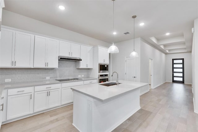 kitchen with visible vents, appliances with stainless steel finishes, light countertops, under cabinet range hood, and a sink