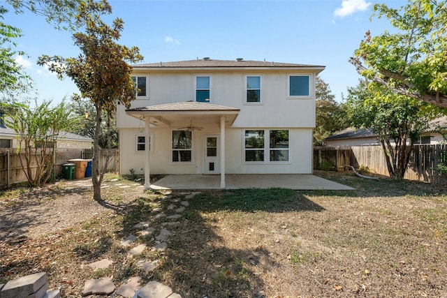 rear view of property with ceiling fan, a yard, and a patio