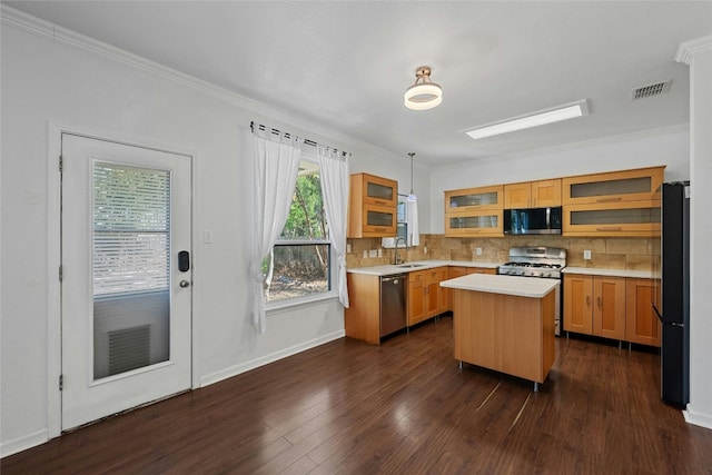 kitchen featuring hanging light fixtures, ornamental molding, stainless steel appliances, dark hardwood / wood-style floors, and a center island