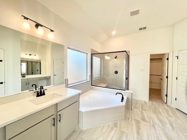 bathroom with vanity, independent shower and bath, and lofted ceiling