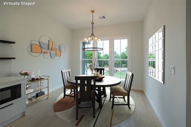 dining room featuring light wood-type flooring and a chandelier