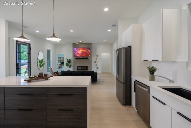 kitchen featuring stainless steel appliances, pendant lighting, white cabinets, and dark brown cabinetry