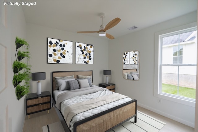 bedroom featuring light hardwood / wood-style flooring, multiple windows, and ceiling fan