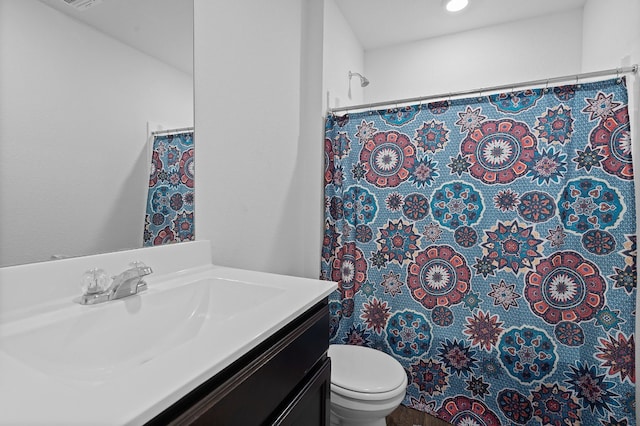 bathroom featuring toilet, vanity, and curtained shower