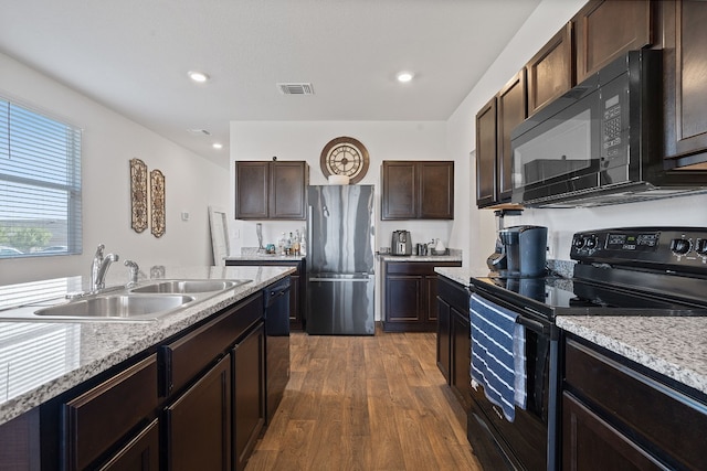 kitchen featuring black appliances, light stone countertops, dark wood-type flooring, sink, and dark brown cabinets