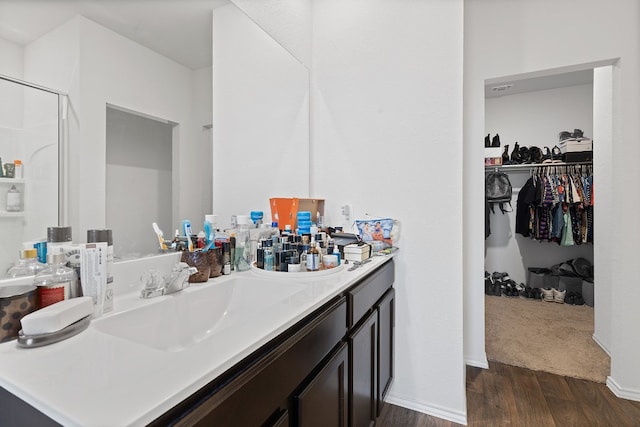 bathroom with hardwood / wood-style flooring, vanity, and an enclosed shower