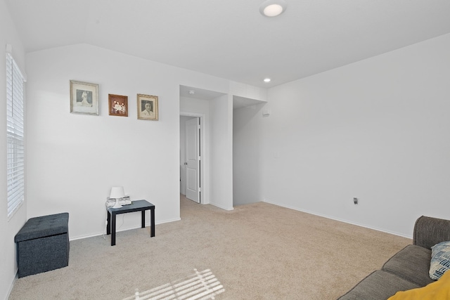 living area featuring light carpet and lofted ceiling