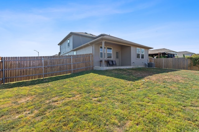 back of property featuring cooling unit and a yard