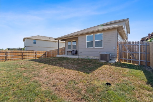 rear view of property featuring central AC and a lawn