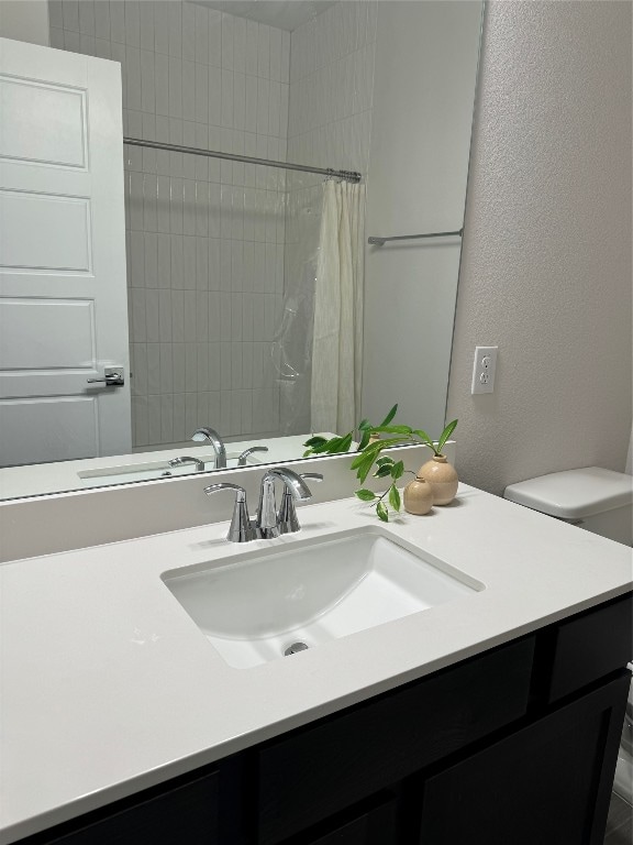 bathroom with walk in shower, vanity, and toilet