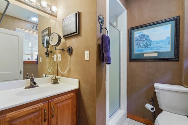 bathroom with a shower with door, vanity, tile patterned flooring, and toilet