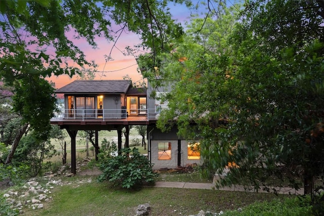 back house at dusk with a deck