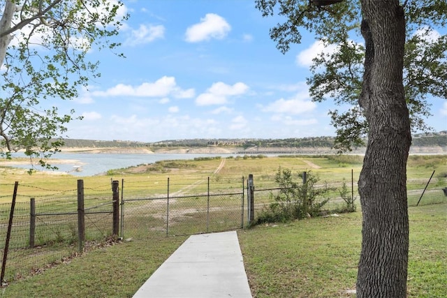 view of yard with a gate, a water view, and fence