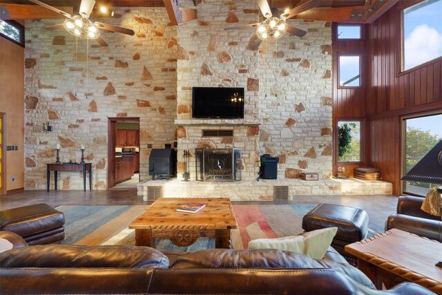 living room with ceiling fan, a fireplace, and a high ceiling