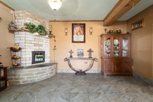 unfurnished living room featuring ceiling fan, a fireplace, and beam ceiling