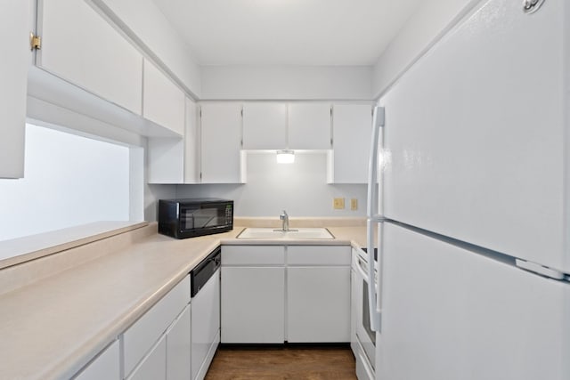 kitchen with white cabinets, dark hardwood / wood-style floors, sink, and white appliances