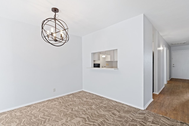 empty room with a chandelier and hardwood / wood-style floors