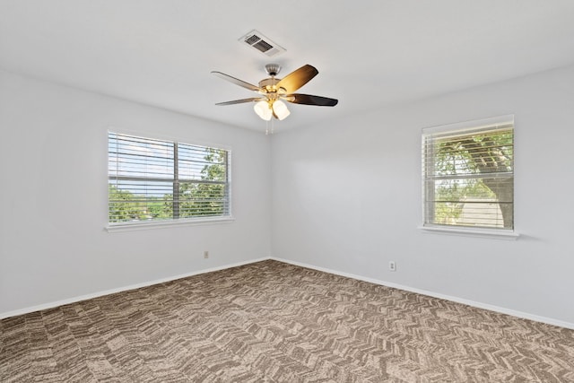 empty room with ceiling fan, plenty of natural light, and light colored carpet