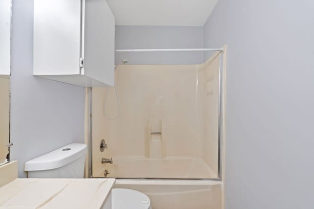 full bathroom featuring toilet, combined bath / shower with glass door, and vanity